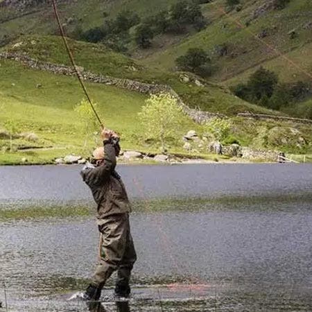 Angler with a single handed fly rod fighting a fish