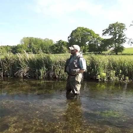 Angler in the water on a chalkstream at mayfly time