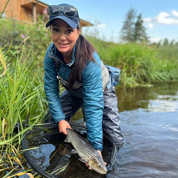 Lucinda with a lovely sea trout with bold markings pictured at waters edge
