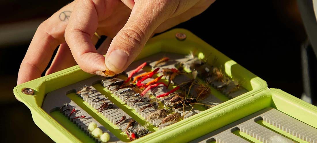 Quality fishing accessories and fly boxes from Orvis Hand holding an Orvis fly box