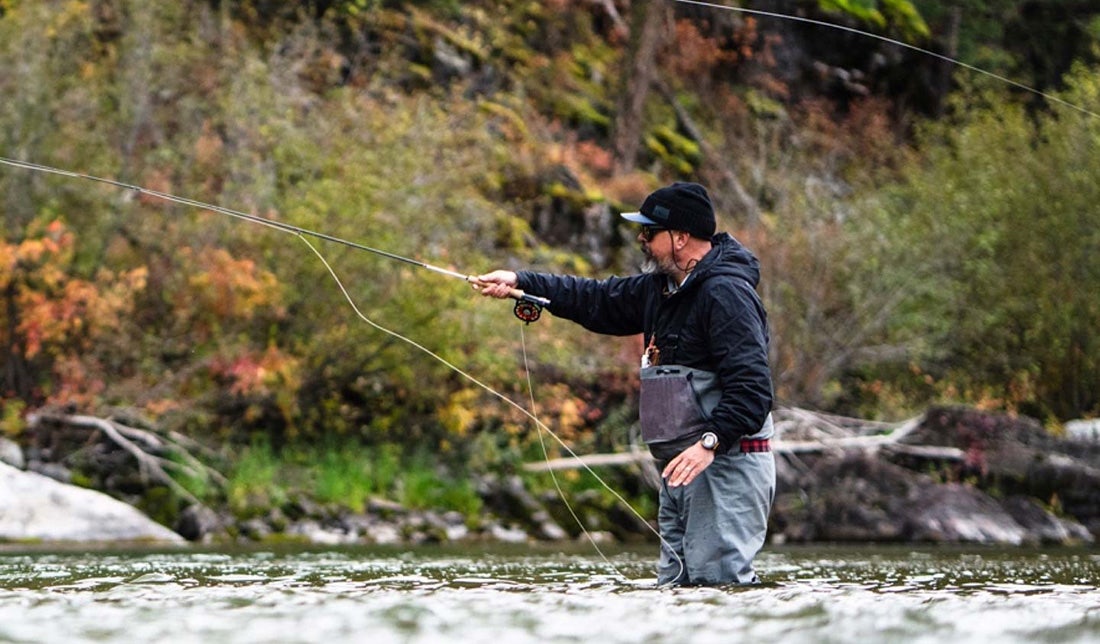 Quality fly fishing tackle from Orvis Man stood in river casting an Orvis fly rod